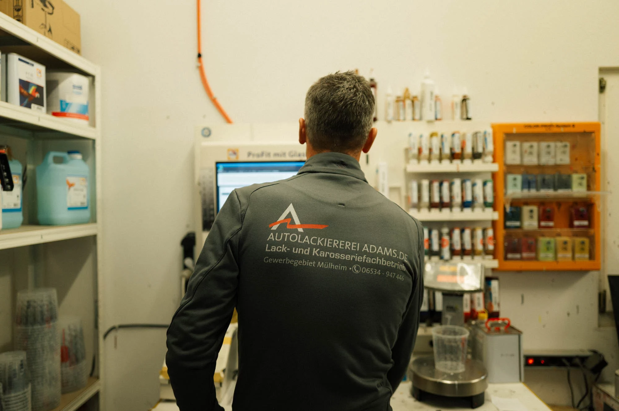 Lackierer am Farbmischsystem im Mischraum